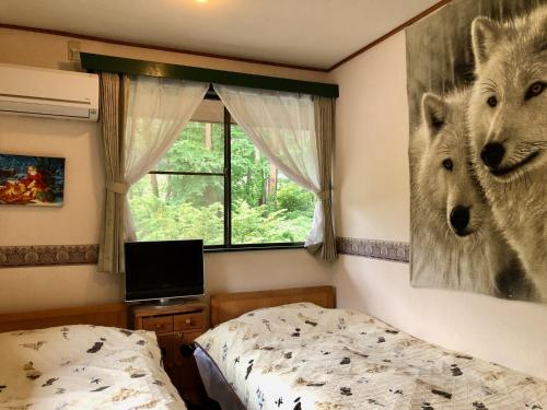 a bedroom with a bear picture on the wall at ドッグランドサムデイ in Minamitsuru