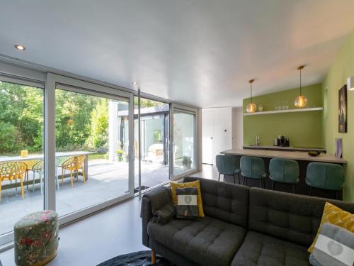 a living room with a couch and a table with chairs at Bungalow in Sint Maartenszee near the beach in Sint Maartensvlotbrug