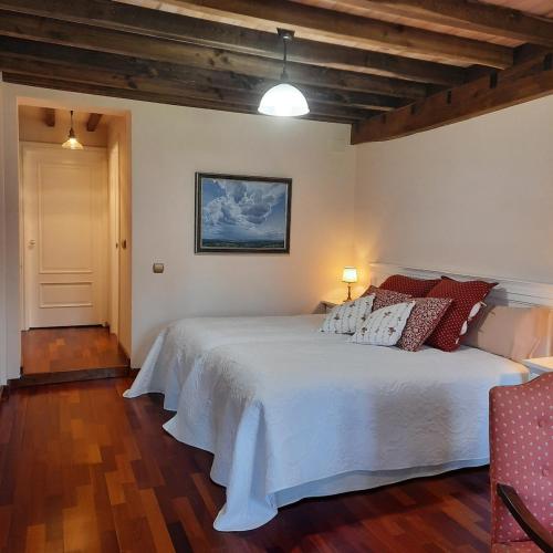 a bedroom with a white bed with pillows on it at La Casina del Pintor in Robledo