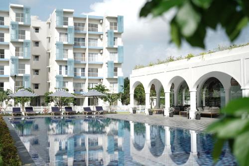 a swimming pool in front of a building at Santorini 2BR Resort Apt - Negombo Beach & Airport in Negombo