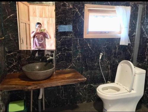 a man taking a picture of a bathroom with a toilet at An House, Farm & Trekking in Tam Ðảo