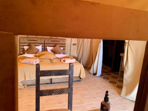 a bedroom with a bed with a ladder next to it at Explore desert in Merzouga