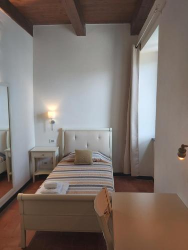 a bedroom with a bed and a table and a window at Albergo Palazzo Costa in Beverino
