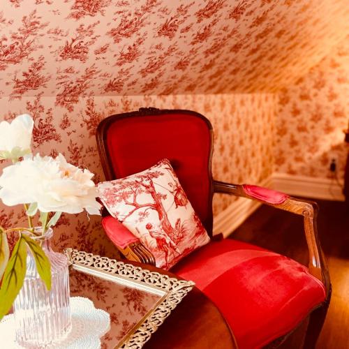 a red chair with a pillow and a table at Maison Rose in Hudson