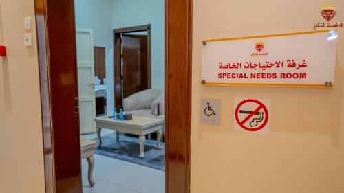a sign on the door of a room with a table at شقق الماسة التاج للوحدات السكنية in Hail