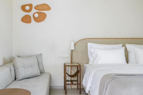 a bedroom with a bed and a couch at Minnŏ Boutique Hotel & Spa in Skopelos Town