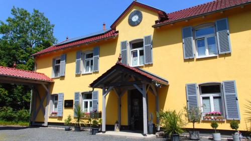 a yellow house with a clock on top of it at Haus Eveline - Ferienwohnungen unterhalb der Wartburg - in Eisenach