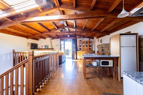 a kitchen with wooden ceilings and a wooden floor at Naturlar Casa do Cura in Beigondo