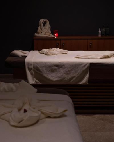 two beds in a room with white sheets on the floor at Avec Hotel in Canakkale