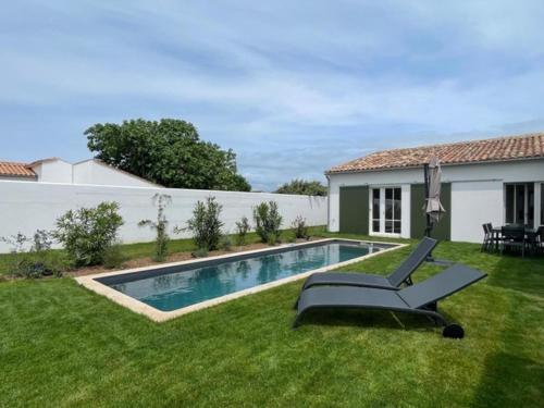 une cour avec une piscine et une maison dans l'établissement La Villa Mirabelle, à Loix