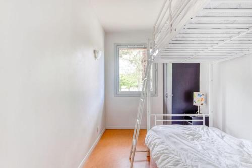 une chambre blanche avec un lit et une fenêtre dans l'établissement Village Vacances Nature de Bellebouche, à Mézières-en-Brenne