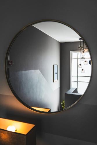 a round mirror on a wall in a bathroom at Reykjavík Rainbow Guesthouse in Reykjavík