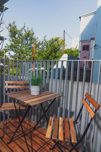 a wooden table and chairs on a deck with a fence at Reykjavík Rainbow Guesthouse in Reykjavík