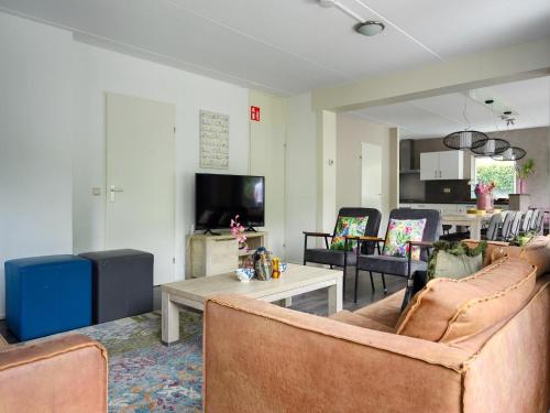 a living room with two couches and a table at Comfortable family and friends house with wellness in Vlagtwedde