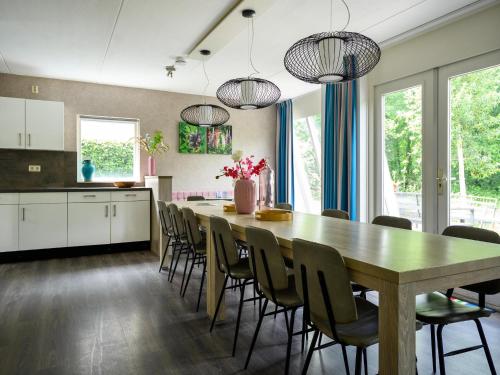 a kitchen and dining room with a table and chairs at Comfortable family and friends house with wellness in Vlagtwedde