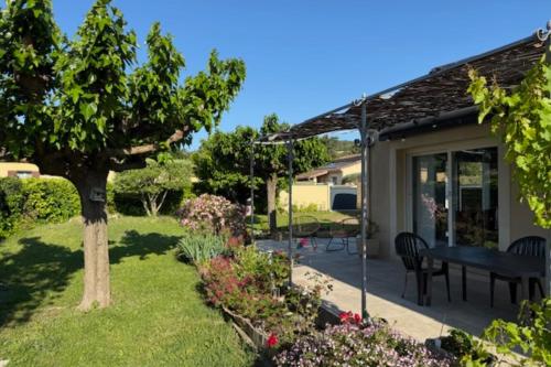 d'une terrasse avec une table et des chaises dans le jardin. dans l'établissement Air-Conditioned House with Private Garden in Le Thor pets are welcome, au Thor