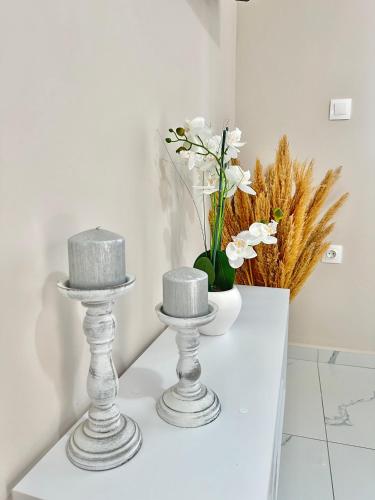 two cakes sitting on a white table with flowers at Aiginetan Apartments in Aegina Town