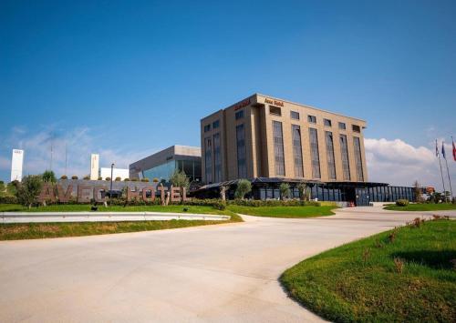 a large building with a road in front of it at Avec Hotel in Canakkale
