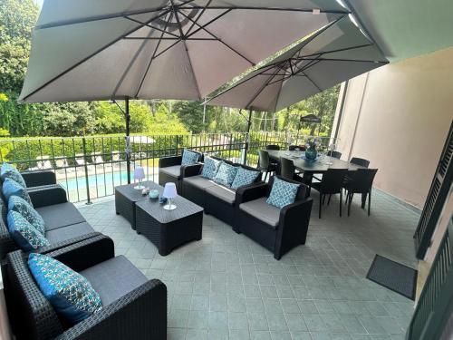 patio z kanapami, stołami i parasolami w obiekcie LightBlue w mieście Marina di Massa