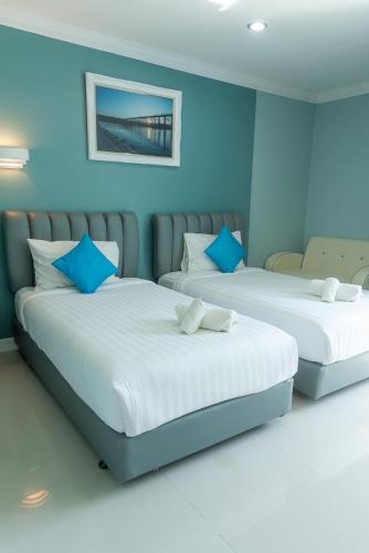 two beds in a room with blue walls at Wangka Resort in Sangkhla Buri