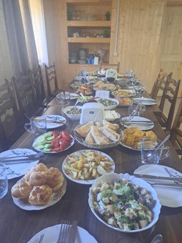 a long table with a bunch of food on it at Chvibiani Guesthouse & Bar in Ushguli