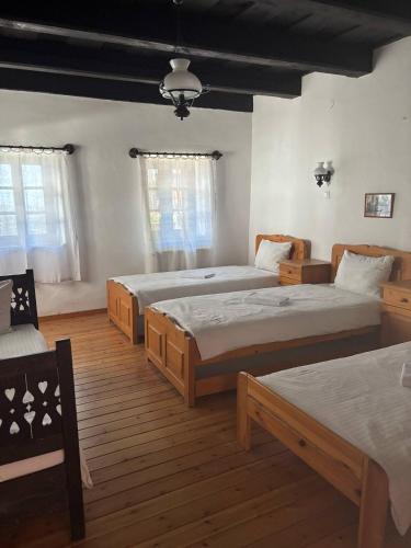 a bedroom with three beds in a room at Hollóköves Vendégházak in Hollókő