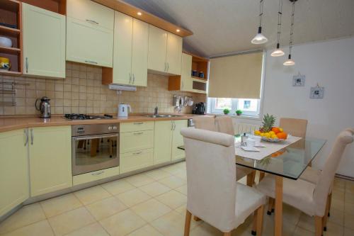 a kitchen with yellow cabinets and a table and chairs at Villa Makarana Apartments in Makarska