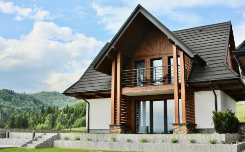 a house with a black roof at Na Skraju Lasu Szlembark in Szlembark