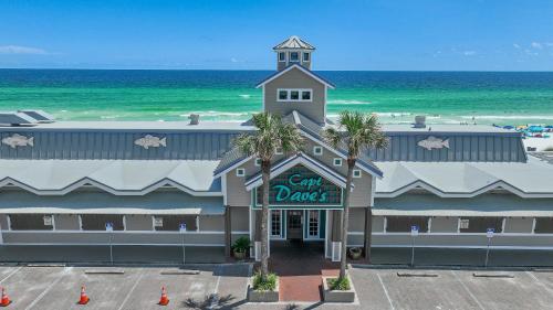 a building with a sign that reads crab dances next to the beach at Pelican Beach Terrace 805 in Destin
