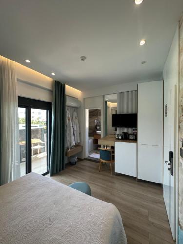 a bedroom with a bed and a room with a desk at Ilio Boutique Hotel in Ksamil