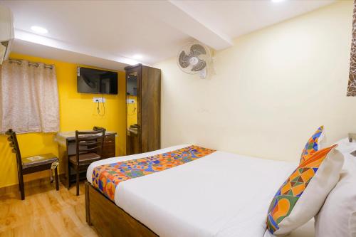 a bedroom with a bed and a desk in it at FabExpress Metro Galaxy Inn - Nesco Exhibition Centre in Mumbai