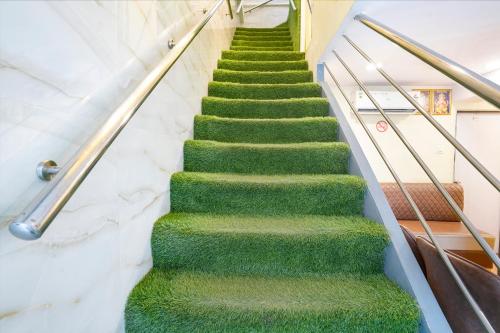 a flight of stairs with green carpet at FabExpress Metro Galaxy Inn - Nesco Exhibition Centre in Mumbai