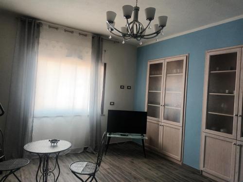 a room with a tv and a table and a chandelier at Valentina's garden house in Triei