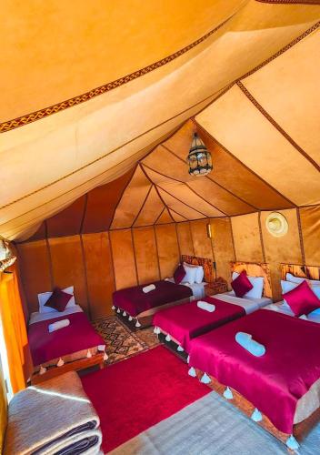 a room with two beds in a tent at Najma Luxury Camp in Merzouga