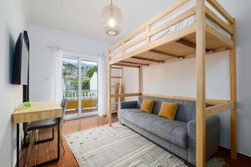a living room with a couch and a loft bed at Vila Gorila - Coastal Home in Porto Formoso