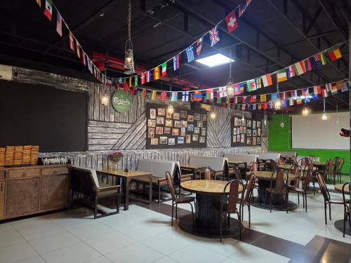 una sala da pranzo con tavoli, sedie e bandiere di Гостиница ОАЗИС a Atyraū