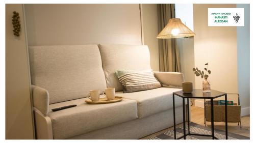 Una sala de estar con un sofá blanco y una mesa. en APARTAMENTOS BOUTIQUE ALTZOAN Aparcamiento gratis y supermercado a 2 metros, en Zarautz