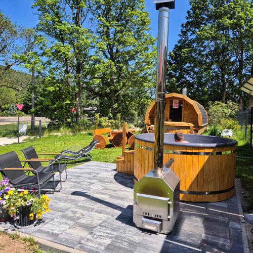 a hot tub and a grill in a yard at Wypoczynkowy Zakątek w Górach in Stronie Śląskie