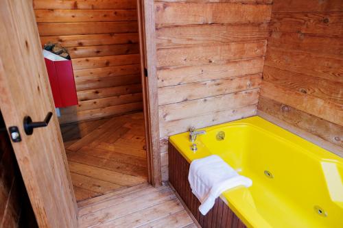 a yellow bath tub in a wooden bathroom at Port Hadlock Luxury Cabin Retreat Awaits you! cabin in Chimacum