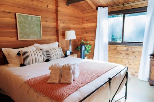 a bedroom with a bed with two pairs of boots on it at Port Hadlock Luxury Cabin Retreat Awaits you! cabin in Chimacum