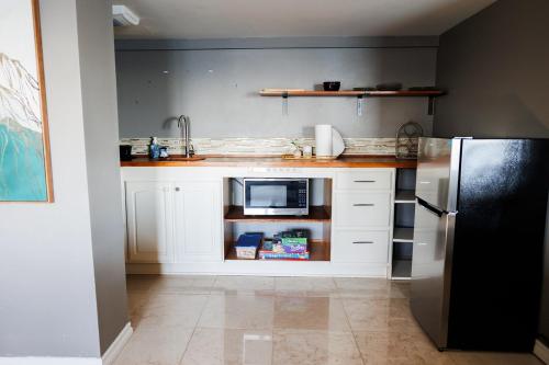 a kitchen with white cabinets and a black refrigerator at Port Hadlock Luxury Cabin Retreat Awaits you! cabin in Chimacum