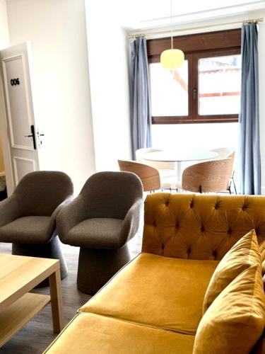 a living room with a couch and chairs and a table at Barbarossa Suites Plaza de España in Merida