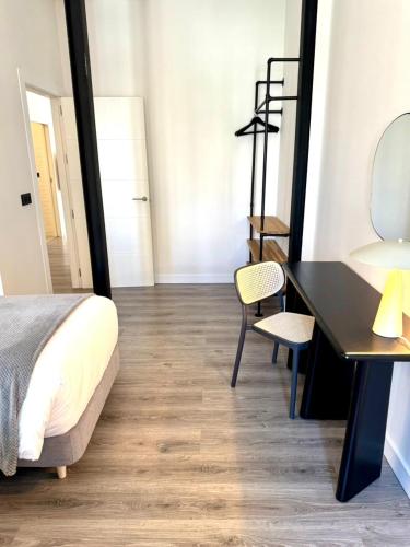 a bedroom with a bed and a desk and a chair at Barbarossa Suites Plaza de España in Merida