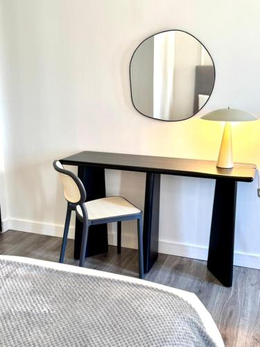 a black desk with a chair and a mirror at Barbarossa Suites Plaza de España in Merida