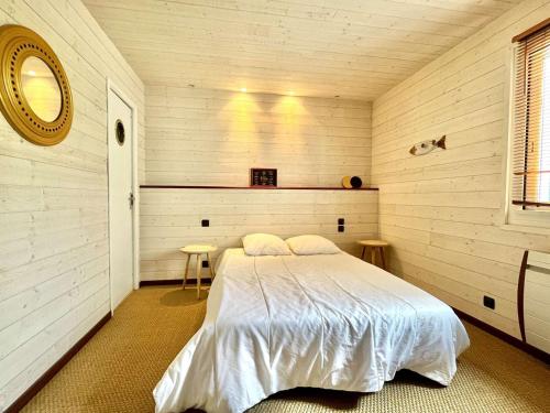 une chambre avec un lit dans une pièce aux murs en bois dans l'établissement Villa calme, terrasses, animaux acceptés, parking, WiFi - FR-1-479-202, à Étel