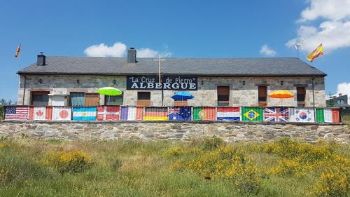 a building with umbrellas on the side of it at Albergue de peregrino Cruz de Fierro in Foncebadón