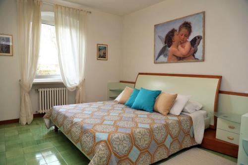 バルドリーノにあるVilla Linda Bardolinoのベッドルーム1室(ベッド1台付)が備わります。壁に絵が飾られています。