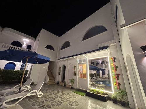a white house with a patio at night at Sea Horse Hotel Dahab in Dahab