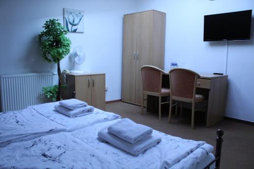 a bedroom with a bed with towels on it at Sporthotel Patriot in Litoměřice
