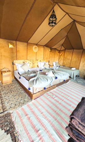 a bedroom with two beds in a tent at Najma Luxury Camp in Merzouga